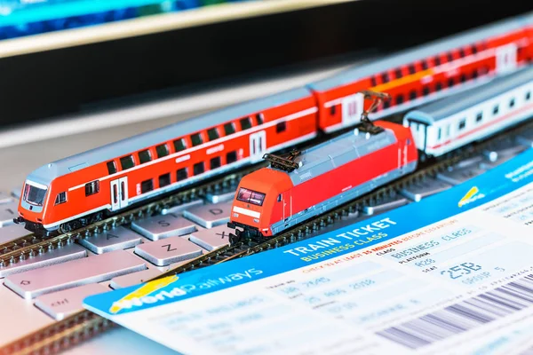 Toy train, tickets, passport and bank card on laptop or notebook — Stock Photo, Image