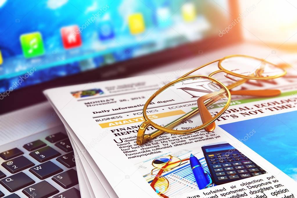 Stack of newspapers on laptop and eyeglasses