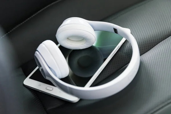 Auriculares y Tablet PC en el asiento del coche — Foto de Stock