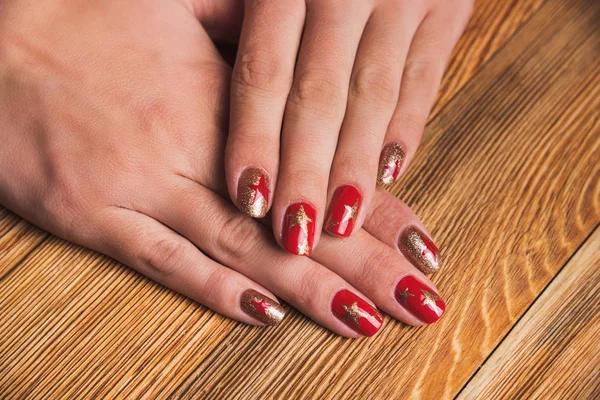 Festive nail art with stars in red and gold colors