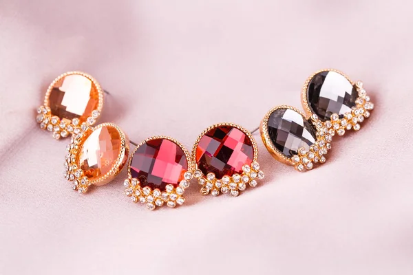 Earrings on silk — Stock Photo, Image