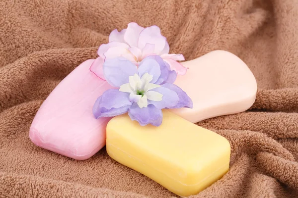 カラフルな石鹸や茶色のタオルの上に花 — ストック写真