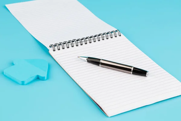 Блокнот, ручка и бумажная стрелка — стоковое фото