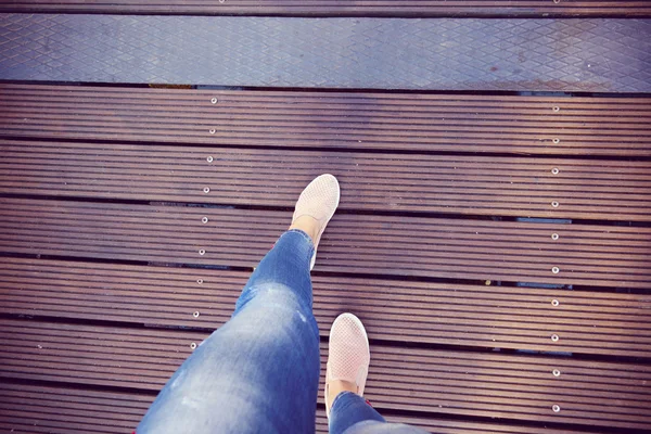 Belle gambe delle donne che camminano attraverso il ponte moderno — Foto Stock