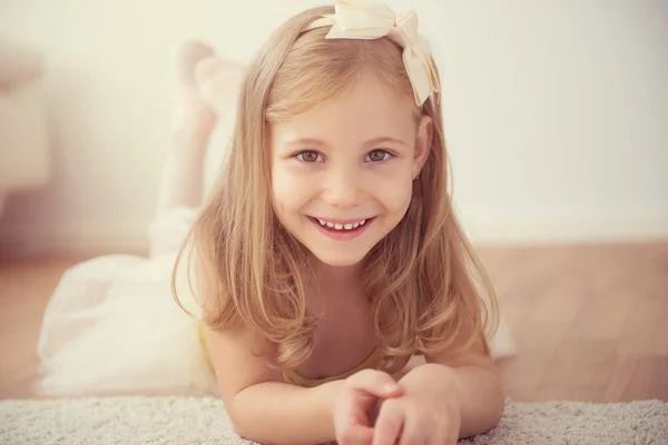 スタジオで白いチュチュで笑顔のかわいいバレエ少女 — ストック写真