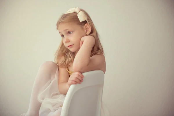 Muito sério ballet menina em branco tutu sentado na cadeira — Fotografia de Stock