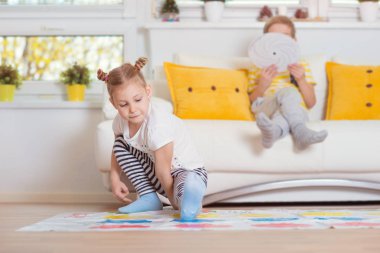 Evde heyecan verici oyun oynayan iki mutlu çocuk