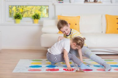 Evde heyecan verici oyun oynayan iki mutlu çocuk