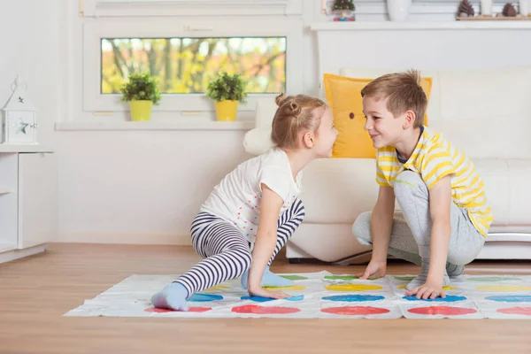 Zwei glückliche Kinder spielen zu Hause ein spannendes Spiel — Stockfoto