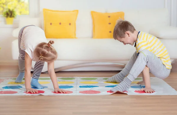 Zwei glückliche Kinder spielen zu Hause ein spannendes Spiel — Stockfoto