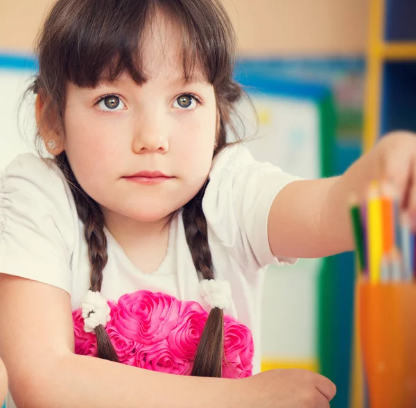 用彩色铅笔在幼儿园画的可爱的小女孩 — 图库照片