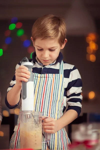 Glad liten pojke förbereder julkakor — Stockfoto