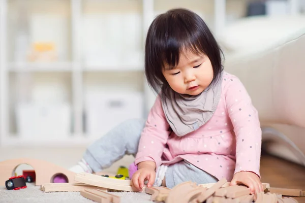 Feliz pouco japonês menina jogar no branco capet em casa — Fotografia de Stock
