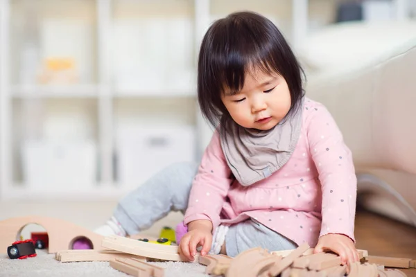 Joyeux petit japonais fille jouer sur blanc capet à la maison — Photo