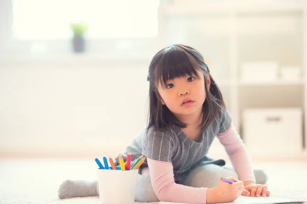 Αρκετά ευχαριστημένος μικρό ιαπωνικό κορίτσι, σχέδιο με μολύβια στο σπίτι — Φωτογραφία Αρχείου