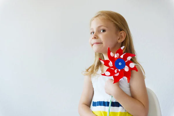 Portrait de jolie petite fille avec moulin à vent rouge le jour d'été — Photo