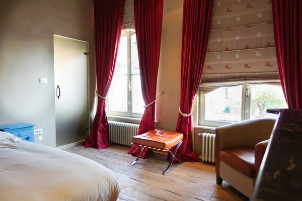 Comfortabele slaapkamer met grote ramen en houten vloeren — Stockfoto