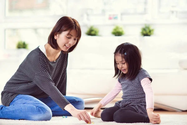 Pretty happy japanese mother play with little daughter at home — Stock Photo, Image