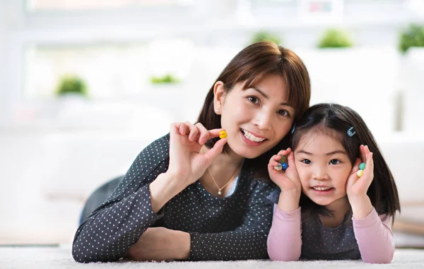 Ganska nöjd japansk mor spela med lilla dotter hemma — Stockfoto