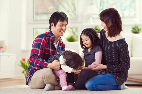 Joven familia feliz con hijas bonitas jugando y divirtiéndose —  Fotos de Stock