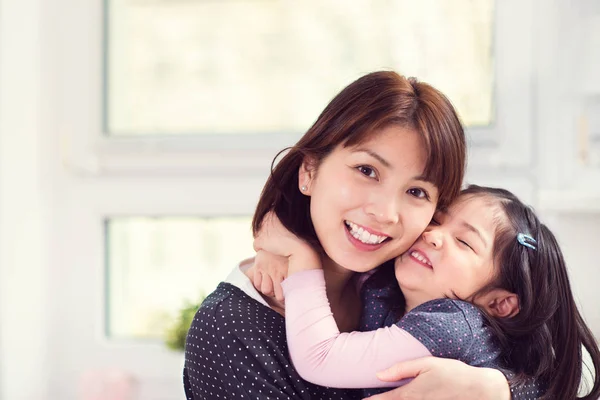 Portrait of happy mother hugging with her cute little daughter a — Stock Photo, Image