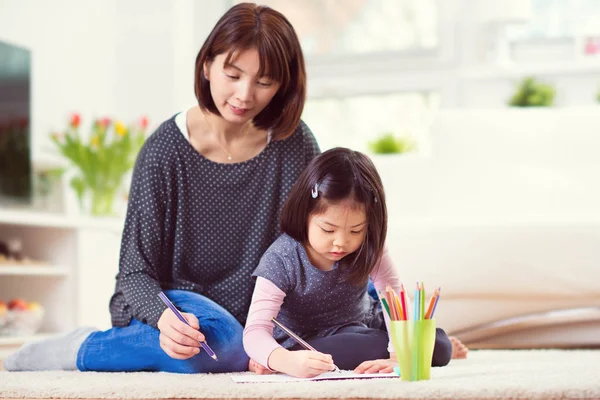 Abbastanza felice madre giocare e disegnare con la sua piccola figlia carina — Foto Stock