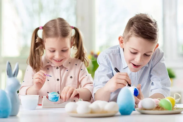 Due bambini felici si divertono durante la pittura uova per Pasqua in — Foto Stock