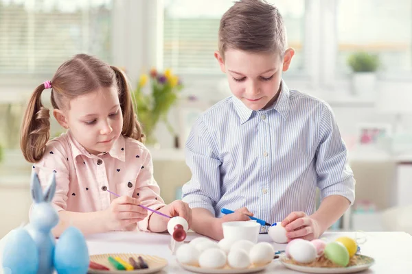 Due bambini felici si divertono durante la pittura uova per Pasqua in — Foto Stock