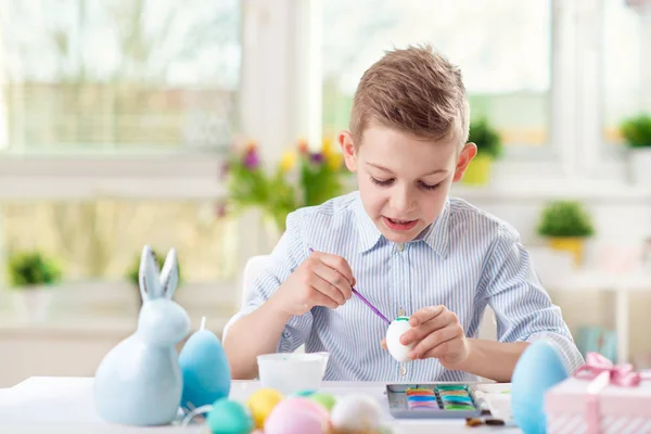 Menino feliz se divertindo durante a pintura de ovos para a Páscoa em sp — Fotografia de Stock