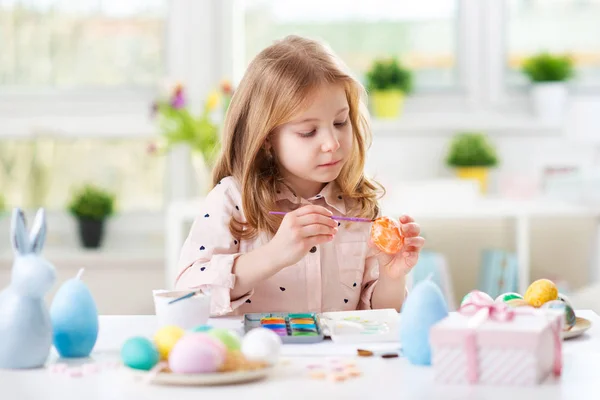 Feliz niña bonita divirtiéndose durante la pintura de huevos para Pascua en primavera —  Fotos de Stock