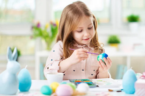 Feliz niña bonita divirtiéndose durante la pintura de huevos para Pascua en primavera —  Fotos de Stock