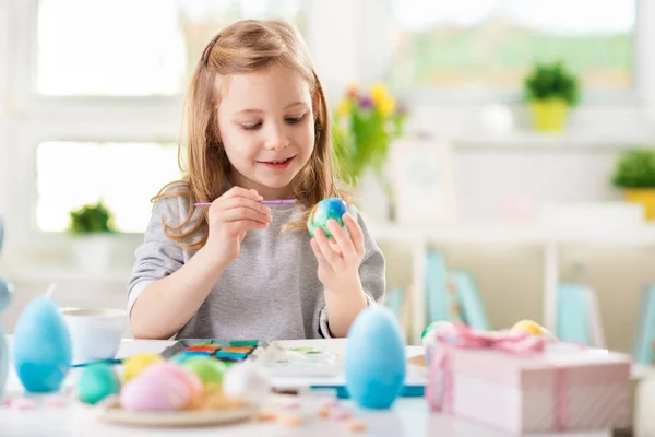 Feliz niña bonita divirtiéndose durante la pintura de huevos para Pascua en primavera — Foto de Stock