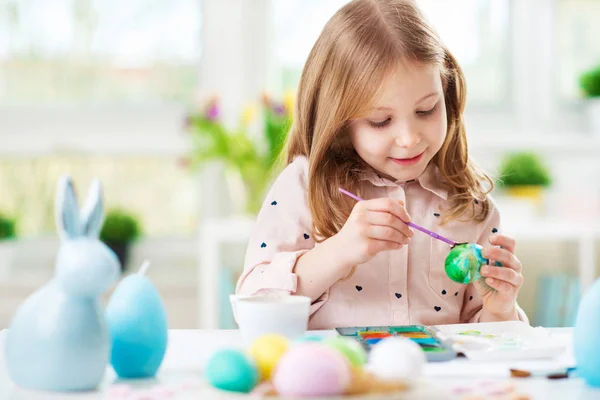 Šťastné dítě hezká dívka baví během malování vajíček na Velikonoce na jaře — Stock fotografie