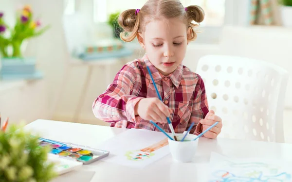 Hübsches kleines Mädchen malt zu Hause mit bunter Farbe — Stockfoto