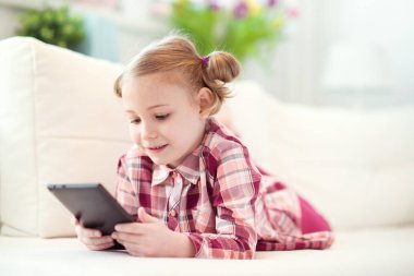 Bir dijital tablet, seyir ve sm kullanarak sevimli küçük çocuk kız