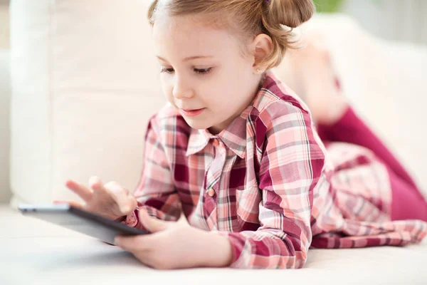 Bastante niña usando una tableta digital, mirando y sm —  Fotos de Stock