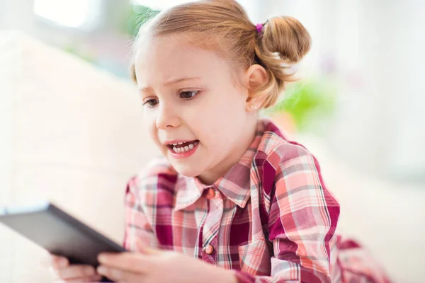 Menina bonita usando um tablet digital, olhando e sm — Fotografia de Stock