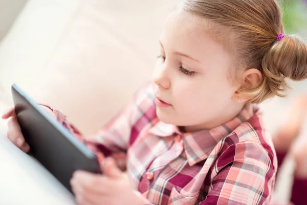 Bastante niña usando una tableta digital, mirando y sm —  Fotos de Stock