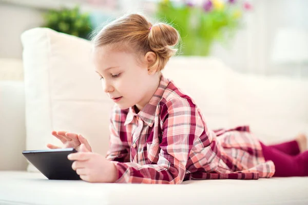 Красавица маленькая девочка с помощью цифрового планшета, глядя и SM — стоковое фото