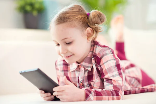 Hübsche kleine Mädchen mit einem digitalen Tablet, suchen und sm — Stockfoto
