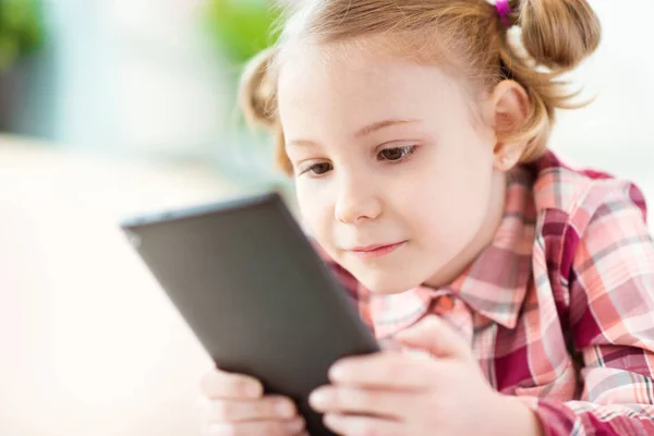 Bastante niña usando una tableta digital, mirando y sm —  Fotos de Stock