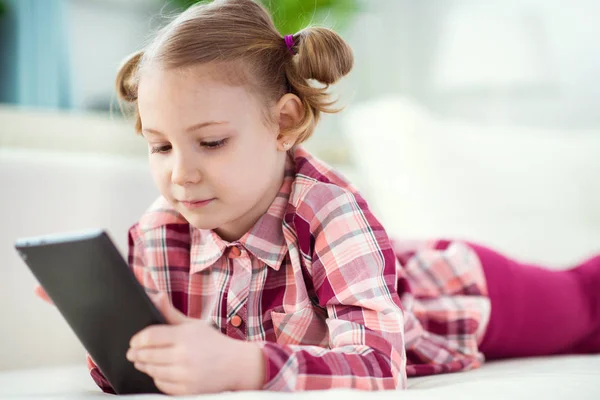 Malá hezká dítě pomocí digitální tabletu, pohledu a sm — Stock fotografie