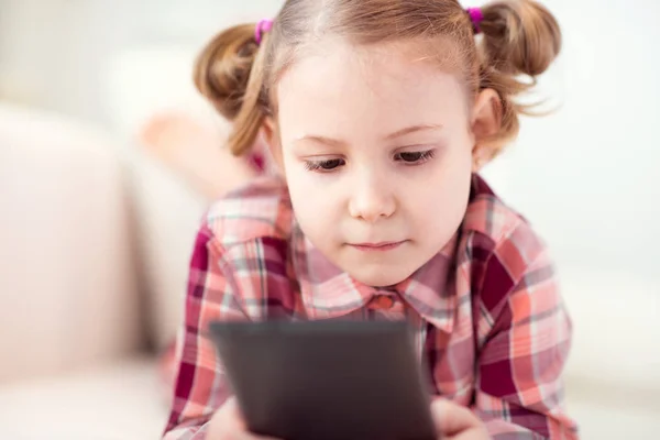 Bastante niña usando una tableta digital, mirando y sm —  Fotos de Stock