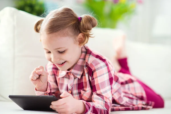Jolie petite fille enfant à l'aide d'une tablette numérique, regarder et sm — Photo