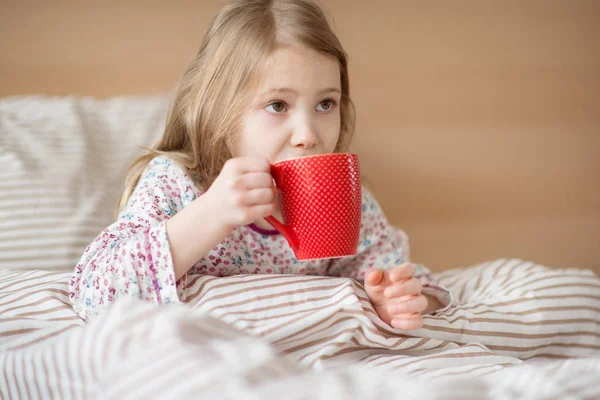 Muito doente menina criança deitado na cama beber chá — Fotografia de Stock