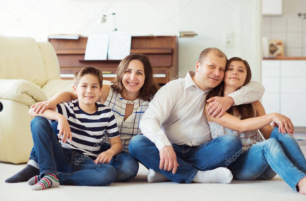 Portrait of young happy family with pretty teenager daughter and