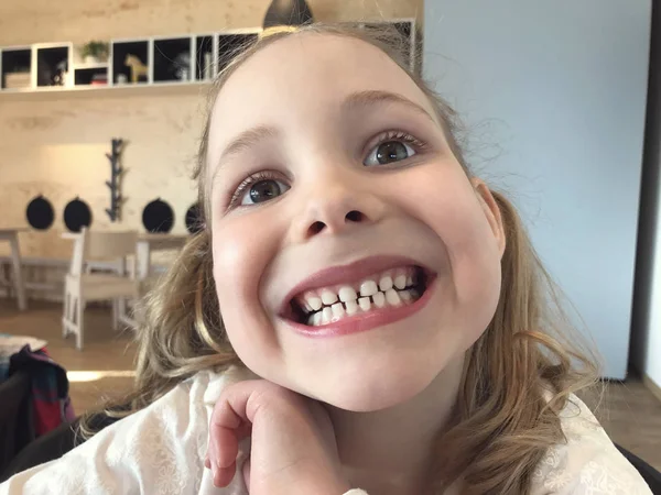 Visage drôle de petite fille avec des dents blanches — Photo