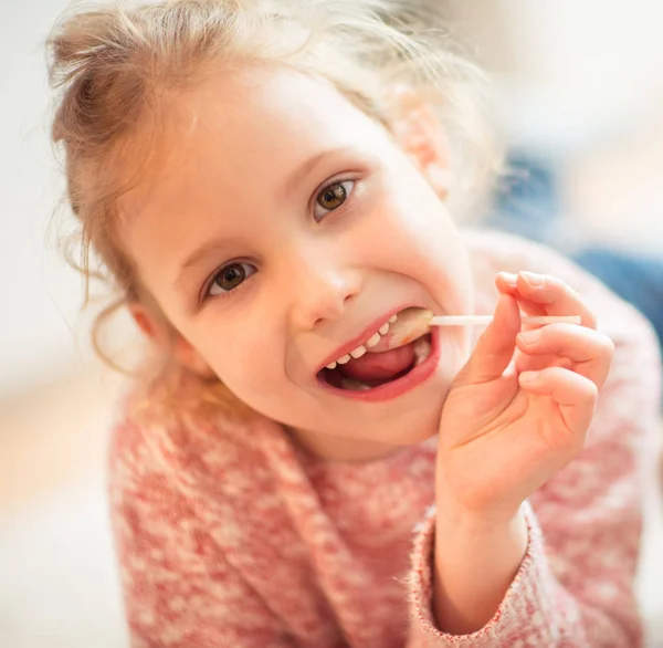 Portrait d'enfant heureuse fille avec lolipop dans sa main — Photo