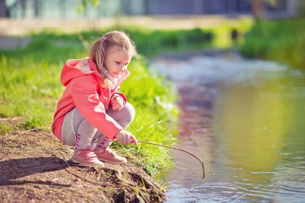 Joyeux adorable petite fille jouant près de l'étang dans la journée ensoleillée — Photo