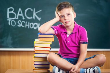 sınıf kitapları ile oturma sevimli okul çocuğu